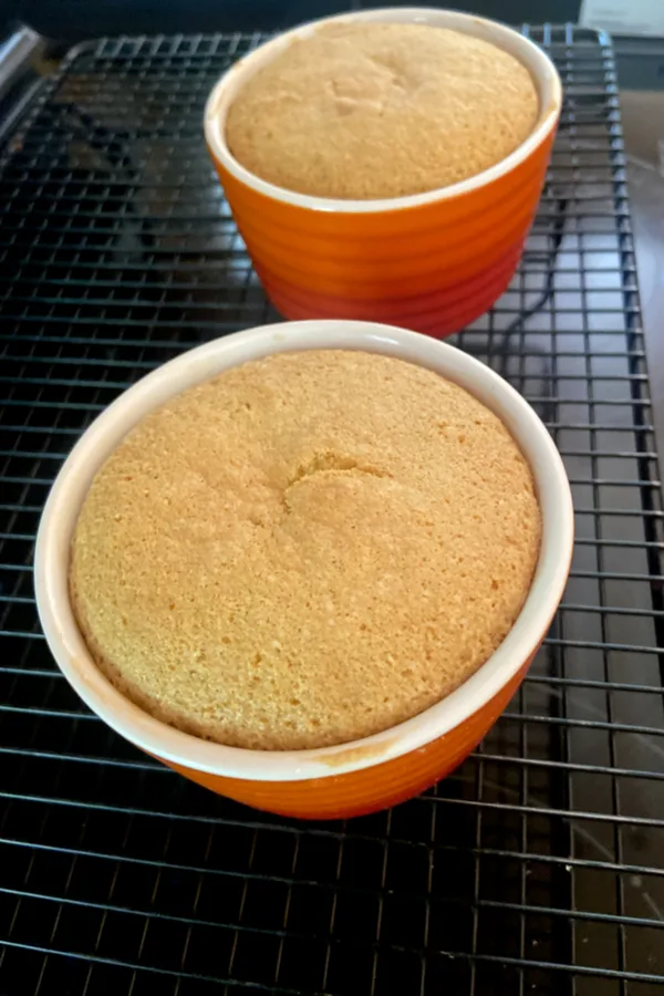 pineapple upside down cake resting in ramekins on cooling rack