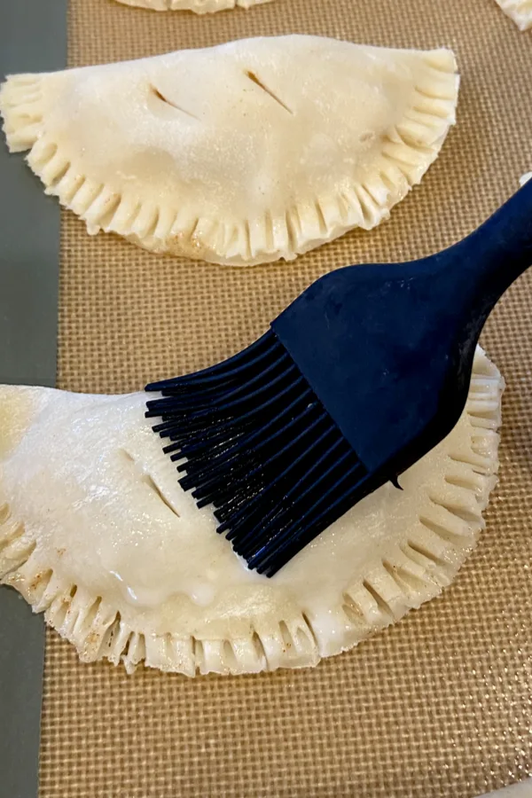 brushing egg wash on pie crust dough