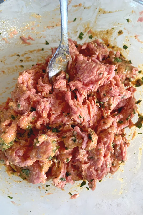 mixing burger meat with fork 