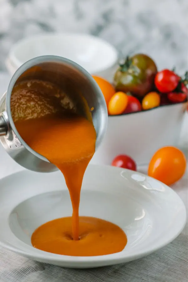 homemade tomato soup pouring in bowl