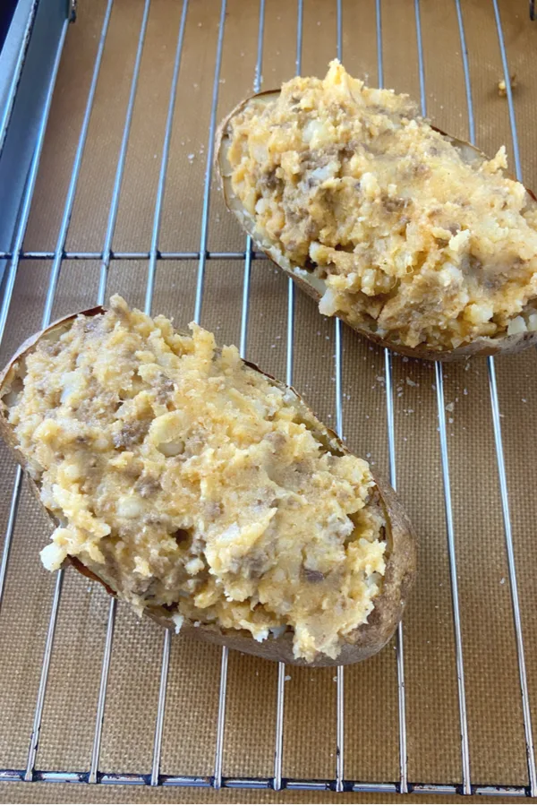 taco meat and potato filling in a baked shell of a potato