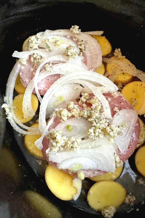 garlic herb butter sauce over onions and pork chops