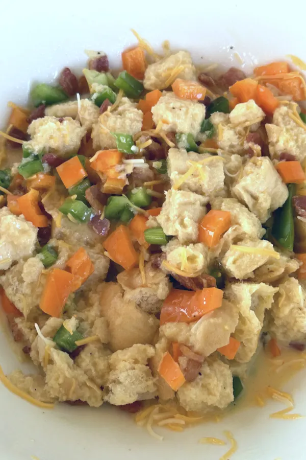 bread cubes and vegetables soaking in egg and milk 