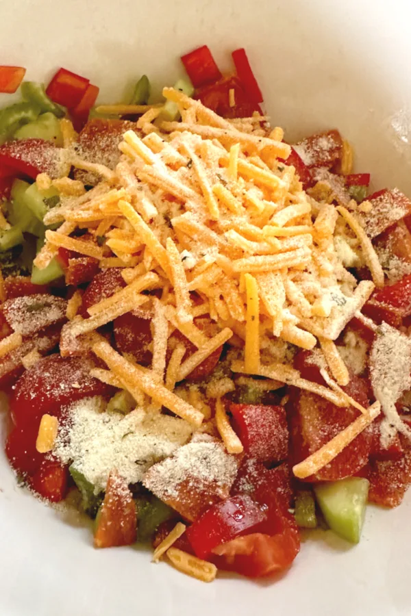 Cheese and ranch dressing over top of chopped vegetables