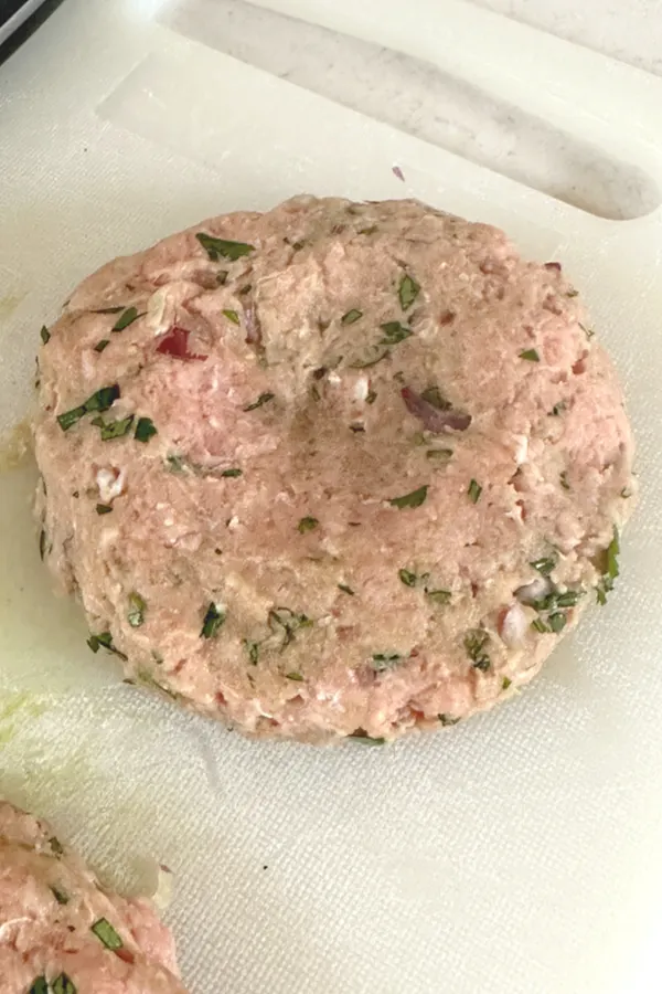 raw burger with indention in center
