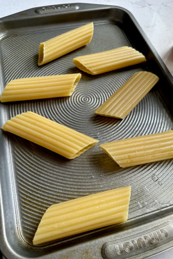 manicotti shells on a greased baking sheet 