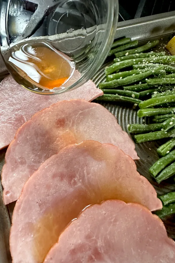 glaze being poured over ham slices