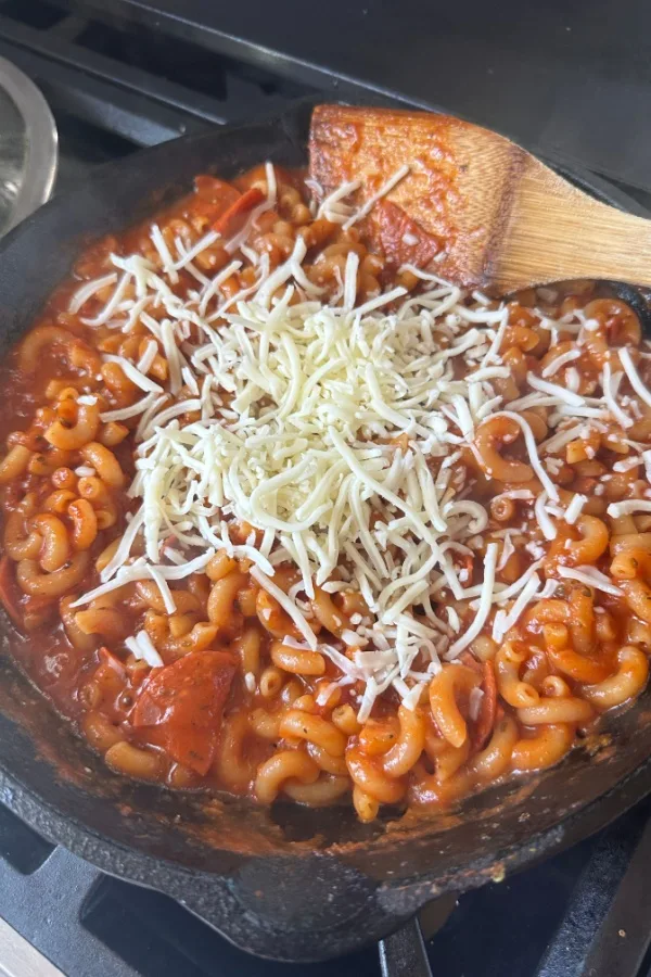 shredded cheese on pasta and sauce