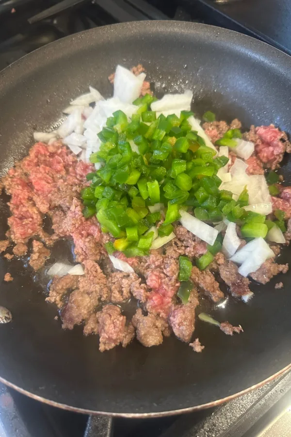 ground beef and diced green peppers and onions in skillet