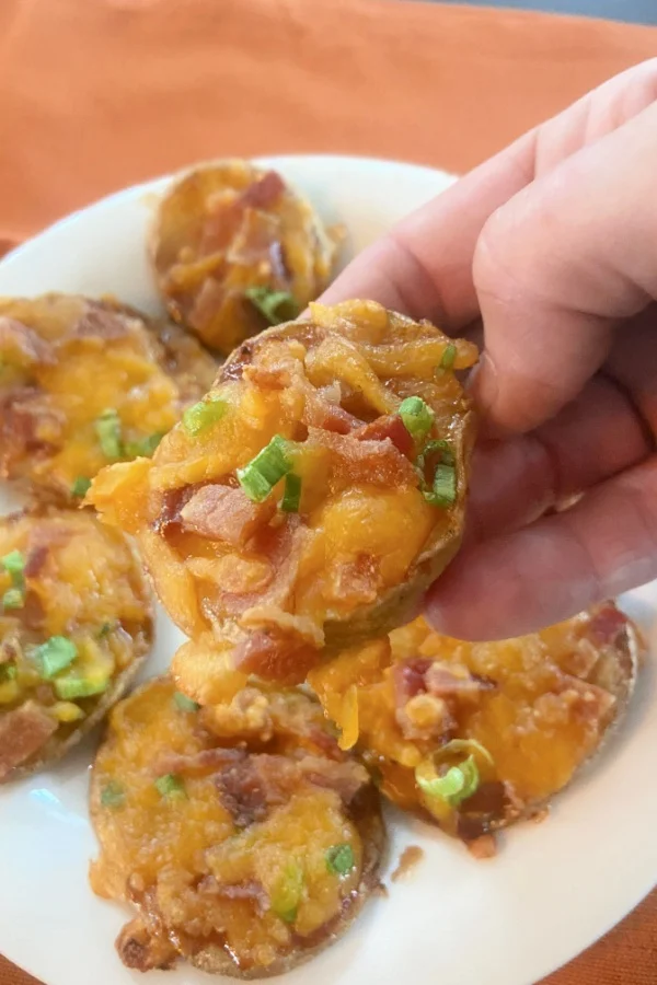 holding up loaded potato rounds