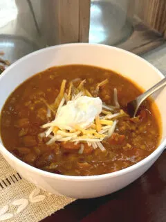 pumpkin chili with shredded cheese and sour cream on top
